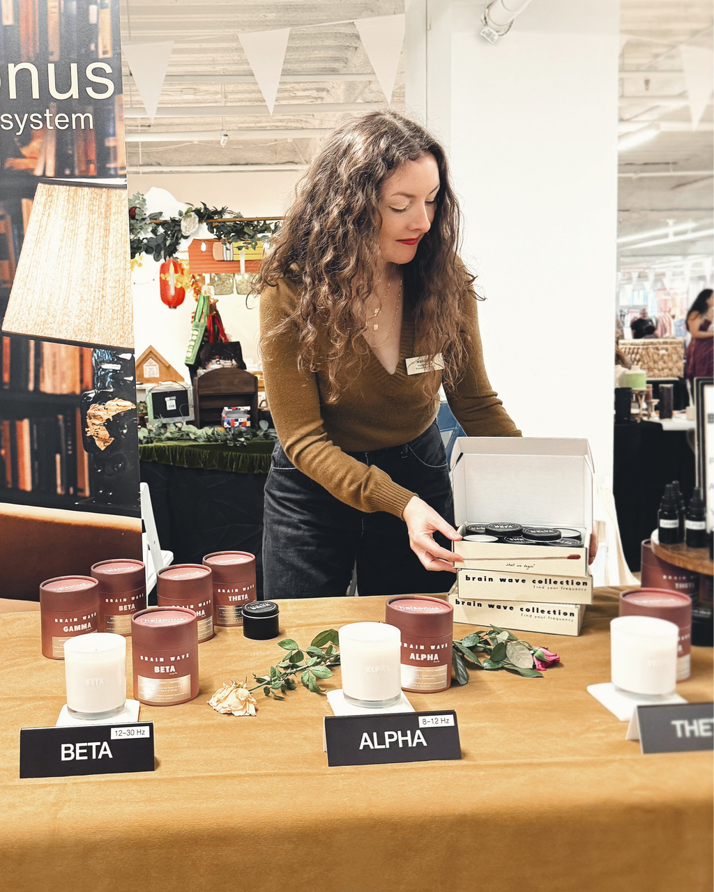 Woman standing at a table with products and a Halsonus banner in the background